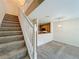 Carpeted staircase with white railings, overlooking the living area and kitchen, with plenty of natural light at 10746 Regent Square Dr # 1502, Orlando, FL 32825