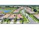 Aerial view of a residential community showcasing well-maintained homes, green lawns, and a scenic pond at 1101 Downswing Pl, Davenport, FL 33896