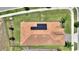 Top-down aerial shot of a home's roof with solar panels, complemented by a well-maintained yard and landscaping at 1101 Downswing Pl, Davenport, FL 33896