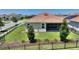 Wide backyard with healthy green grass, trees, and screened-in porch beyond a black fence at 1101 Downswing Pl, Davenport, FL 33896