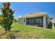 Picturesque backyard featuring a manicured lawn, mature trees, and a screened-in patio at 1101 Downswing Pl, Davenport, FL 33896