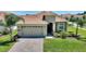 Charming single-story home with a tile roof, brick-paved driveway, and well-manicured landscaping at 1101 Downswing Pl, Davenport, FL 33896