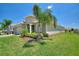 Landscaped front yard with a beautiful lawn, palm trees, and stone accents on the home's facade at 1101 Downswing Pl, Davenport, FL 33896
