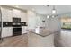 Modern kitchen with white cabinets, stainless steel appliances, and a gray quartz countertop at 1101 Downswing Pl, Davenport, FL 33896