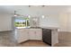 Open kitchen featuring white cabinets, gray countertops, and a view of the adjacent living area at 1101 Downswing Pl, Davenport, FL 33896