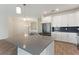 Bright kitchen with white cabinets, black backsplash, stainless steel appliances, and a large island at 1101 Downswing Pl, Davenport, FL 33896