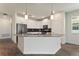 Stylish kitchen with white cabinetry, stainless steel appliances, and a spacious island with seating at 1101 Downswing Pl, Davenport, FL 33896