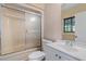 Bathroom featuring a shower, white toilet, and single sink vanity with a window at 11323 Kijik Trl, Groveland, FL 34736