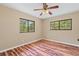 Bedroom featuring hardwood floors, a ceiling fan, and windows offering a scenic view at 11323 Kijik Trl, Groveland, FL 34736