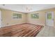 Spacious bedroom featuring hardwood floors, a ceiling fan, and natural light from two windows at 11323 Kijik Trl, Groveland, FL 34736