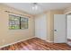 Bedroom features hardwood floors, a window, and double door closet at 11323 Kijik Trl, Groveland, FL 34736