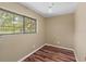 Cozy bedroom with a large window offering outdoor views and wood-look flooring at 11323 Kijik Trl, Groveland, FL 34736