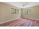 Bright bedroom with wood-look flooring, two windows, and neutral walls for a comfortable living space at 11323 Kijik Trl, Groveland, FL 34736