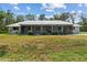Charming single-story home with a metal roof and covered porch; awaiting your personal touch at 11323 Kijik Trl, Groveland, FL 34736