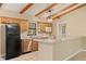 Cozy kitchen with exposed beam ceiling, breakfast bar, and stainless steel appliances at 11323 Kijik Trl, Groveland, FL 34736
