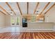 Open-concept kitchen and living room with tile and wood floors, ceiling fans, and outdoor access at 11323 Kijik Trl, Groveland, FL 34736