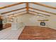 Open-concept living room boasts wood beam ceilings and stone fireplace, seamlessly flowing into the kitchen at 11323 Kijik Trl, Groveland, FL 34736