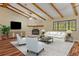 Comfortable living room with stone fireplace, exposed beam ceiling and wood floors at 11323 Kijik Trl, Groveland, FL 34736