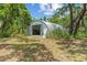 Exterior of a metal outbuilding on a well-maintained, grassy lot with mature trees at 11323 Kijik Trl, Groveland, FL 34736