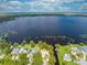 Aerial view of the property with a large lake, landscaped yard, private dock, and surrounding neighborhood at 1186 Laguna Cir, St Cloud, FL 34771