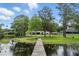 Waterfront property with a long pier, lush landscaping, and serene lake views at 1186 Laguna Cir, St Cloud, FL 34771