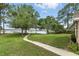 Backyard lawn featuring a walkway, mature trees, and a serene view of the lake and private dock at 1186 Laguna Cir, St Cloud, FL 34771