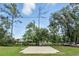 Backyard features a concrete patio, large trees, and plenty of open space at 1186 Laguna Cir, St Cloud, FL 34771