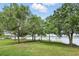 Spacious backyard with lush lawn, mature trees, and a private dock leading to the tranquil lake at 1186 Laguna Cir, St Cloud, FL 34771