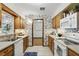 Traditional kitchen featuring oak cabinets, tiled floors, and floral wallpaper at 1186 Laguna Cir, St Cloud, FL 34771
