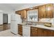 Functional kitchen boasting oak cabinets, a double sink, and view of the back yard at 1186 Laguna Cir, St Cloud, FL 34771