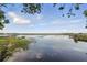 Expansive lake view showcasing clear water and lush shoreline with docks under a partly cloudy sky at 1186 Laguna Cir, St Cloud, FL 34771