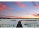 Scenic lake view with a wooden dock stretching into the water under a colorful sky at 1186 Laguna Cir, St Cloud, FL 34771