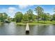 Waterfront scene featuring a wooden dock stretching into the lake, flanked by lush green landscape and clear skies at 1186 Laguna Cir, St Cloud, FL 34771
