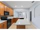 Bright kitchen featuring stainless steel appliances, wood cabinetry, and a center island with quartz counters at 13636 Beauregard Pl, Orlando, FL 32837