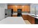 Well-lit kitchen with wood cabinetry, quartz countertops, and modern black appliances at 13636 Beauregard Pl, Orlando, FL 32837
