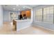 Open-concept kitchen with wood cabinets, quartz countertop bar, and stainless steel appliances at 13636 Beauregard Pl, Orlando, FL 32837