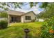 The backyard features a screened-in lanai, lush landscaping, and a privacy fence at 14167 Bradbury Rd, Orlando, FL 32828