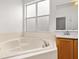 Bathroom features a soaking tub with a frosted window for privacy at 14167 Bradbury Rd, Orlando, FL 32828