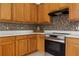 A well-lit kitchen features oak cabinets, mosaic backsplash, stainless steel appliances, and spacious countertops at 14167 Bradbury Rd, Orlando, FL 32828