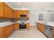 Well-lit kitchen featuring wood cabinets, stainless steel appliances, mosaic backsplash, and ample countertop space at 14167 Bradbury Rd, Orlando, FL 32828