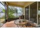 A screened-in lanai provides a relaxing space to enjoy the outdoors, featuring a table and chairs at 14167 Bradbury Rd, Orlando, FL 32828