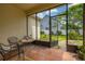 The cozy screened lanai features a table, chairs, and access to the lush backyard at 14167 Bradbury Rd, Orlando, FL 32828