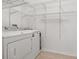 Convenient laundry room with washer, dryer, and shelving for ample storage at 14167 Bradbury Rd, Orlando, FL 32828