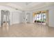 A spacious living room with neutral tile flooring, a tray ceiling, and sliding glass doors to the lanai at 14167 Bradbury Rd, Orlando, FL 32828