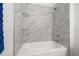Close up of a marble tiled shower featuring a showerhead and shelf at 14167 Bradbury Rd, Orlando, FL 32828