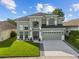 Two-story home boasting a manicured lawn, lush landscaping, and a two-car garage at 14412 Saint Georges Hill Dr, Orlando, FL 32828
