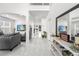 Bright foyer with white marble floors, gray sofa, console table, and hallway leading to the rest of the home at 14412 Saint Georges Hill Dr, Orlando, FL 32828