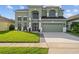 Well-maintained two-story home with a lush front yard, a two-car garage and an arched entryway at 14412 Saint Georges Hill Dr, Orlando, FL 32828