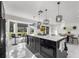 Open-concept kitchen with large island, black cabinetry, pendant lighting, and a view to the backyard at 14412 Saint Georges Hill Dr, Orlando, FL 32828
