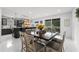 Open layout with kitchen island, dining area, access to backyard, and modern gray chairs at 14412 Saint Georges Hill Dr, Orlando, FL 32828